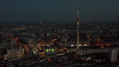 Hermosa-Vista-Sobre-Berlín,-Alemania-Al-Anochecer-Después-Del-Atardecer-Con-Luces-De-La-Ciudad-Parpadeando-Y-Rascacielos-De-La-Torre-De-Televisión,-Impresionante-Vista-Aérea-Amplia