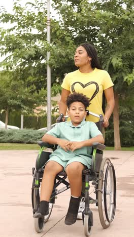 woman pushing a child in a wheelchair outdoors