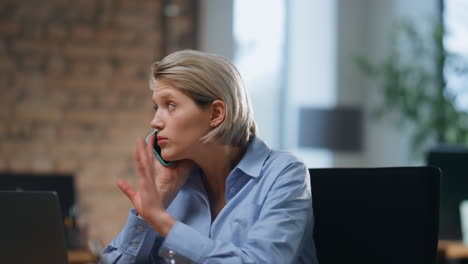 concerned worker talking cellphone sitting modern office after work day close up