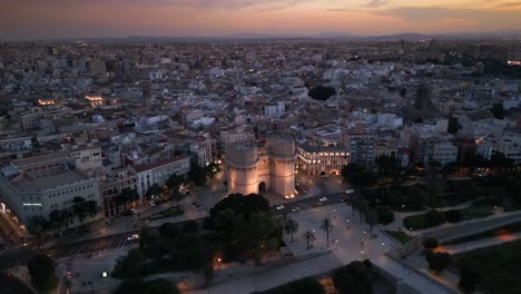 Aerial-view-Landmark-Torres-de-Serranos,-Historic-City-Gates-at-Dusk,-Valencia-Spain-4K