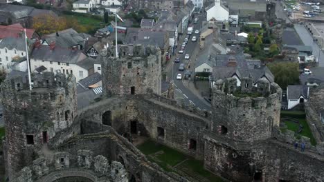 historic conwy castle aerial view of landmark town ruin stone wall battlements tourist attraction birdseye pull away left