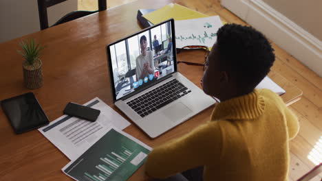 african american woman using laptop on video call with female colleague working from home