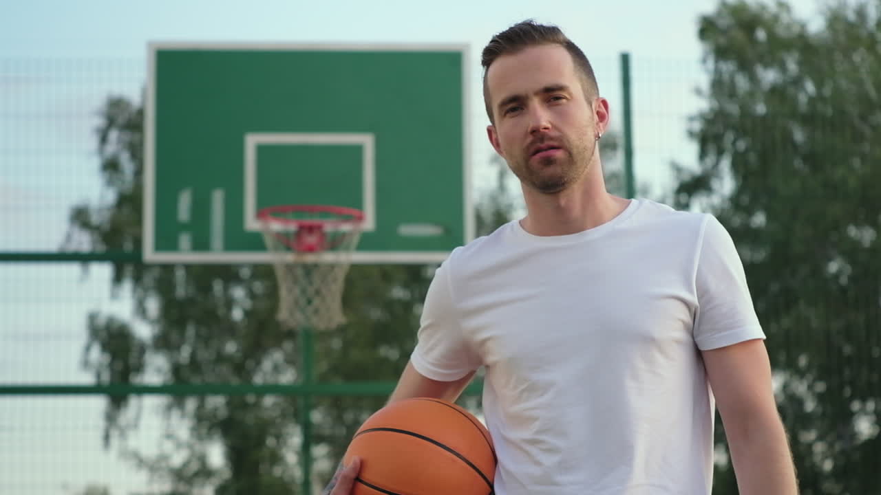 hombre sosteniendo una pelota de baloncesto en una cancha