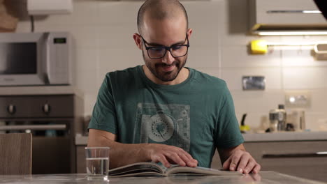 Caucasian-man-studies-and-flips-pages-of-a-textbook