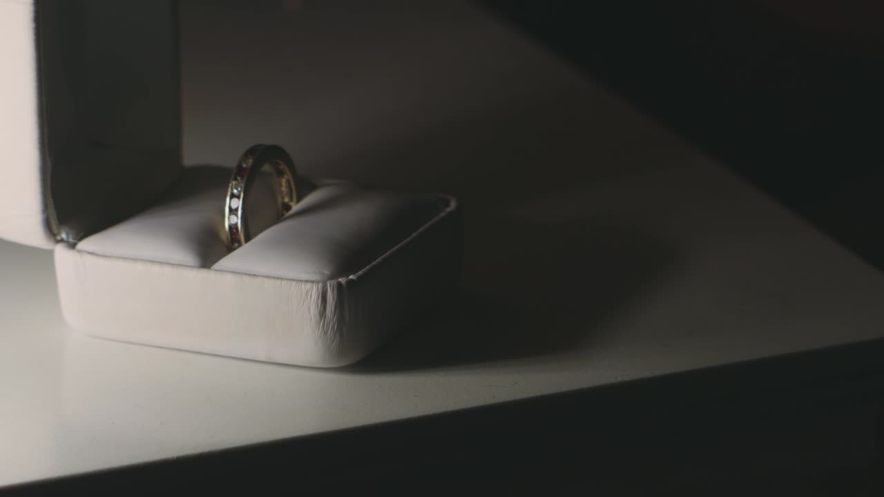 Hand Takes The Wedding Ring From The Jewelry Gift Box On The Table - close up
