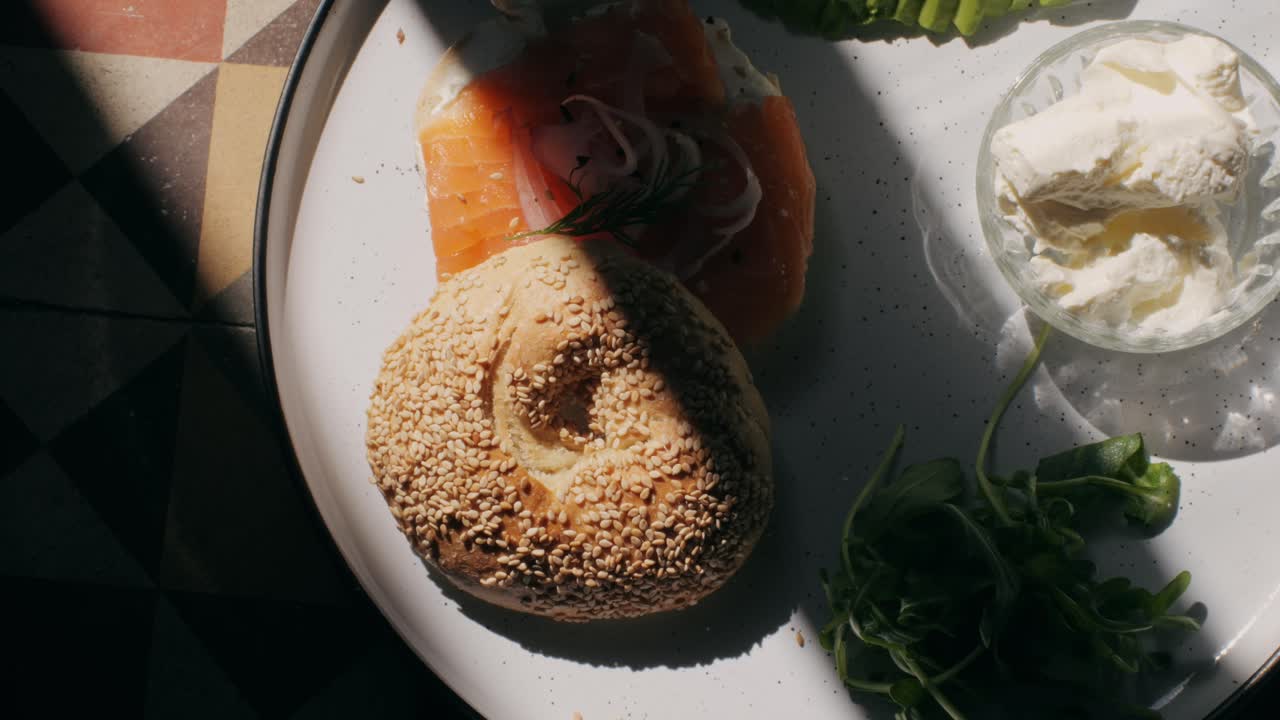 Bagel sandwich brunch, lunch plate of a bagel with smoked salmon and cream cheese and ham, close up morning cafe menu.