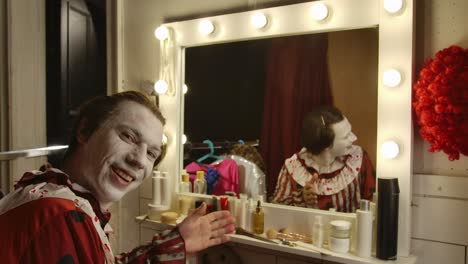 clown putting on makeup in a dressing room with a vanity mirror