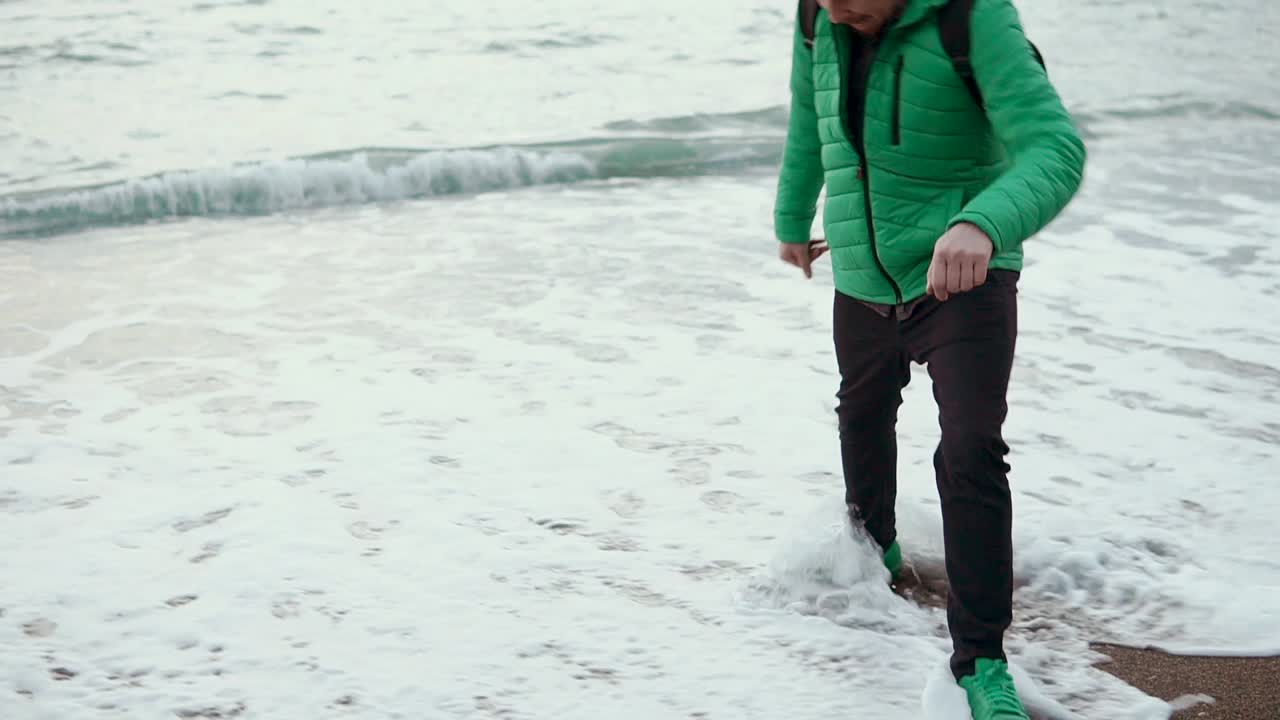 Hombre caminando por la playa al atardecer