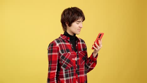 young person with a disgusted expression looking at their red smartphone on a yellow background