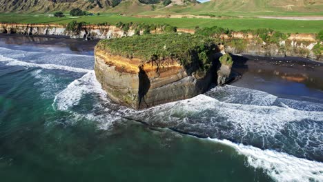 rugged ocean coastline with rocky outcrop in new zealand