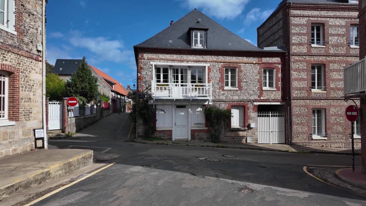 Traditionelle Gebäude aus Feuerstein und rotem Backstein rund um eine Dorfkreuzung in Veules-les-Roses, Normandie, Frankreich