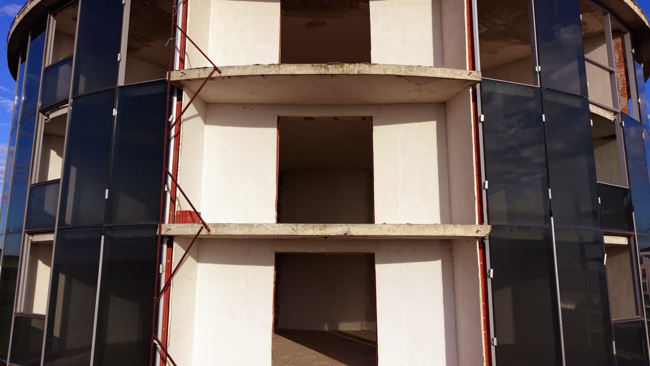 Si erge lungo la facciata con porte e balconi vuoti. Edificio arrotondato in costruzione