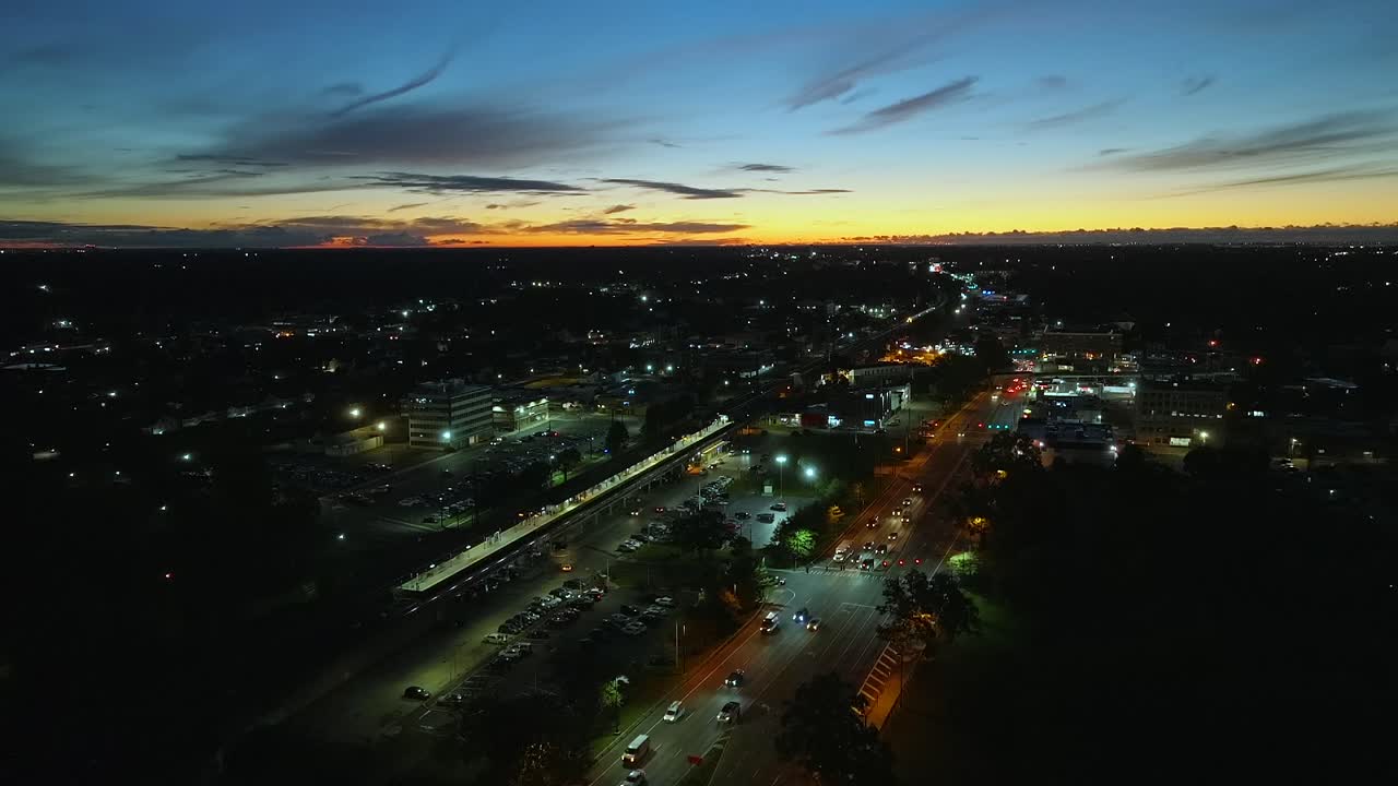 una vista aérea de la autopista del amanecer y una estación de tren del ferrocarril de long island al amanecer
