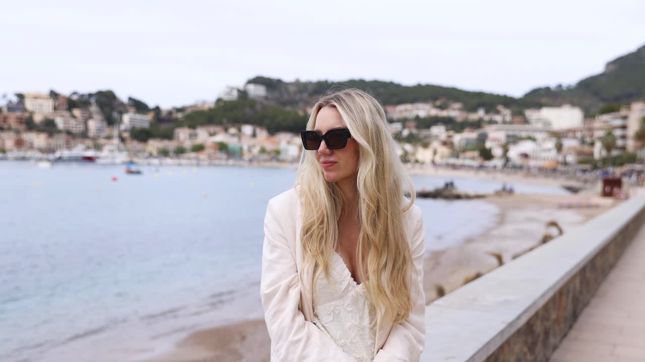Female Tourist With Blonde Hair Sitting At Promenade In Port de Soller, Mallorca, Spain