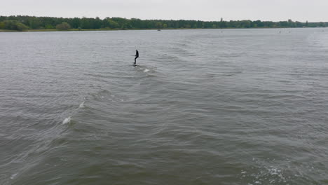 athlete on hydro sup foil surf in wave on a river and fall in water