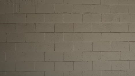 a close up of a camera moving towards a concrete brick white wall