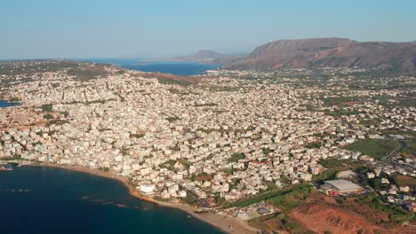 high aerial over chania buildings and blue water, idyllic scene of crete island - greece