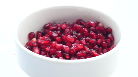 pomegranate seeds in a white bowl