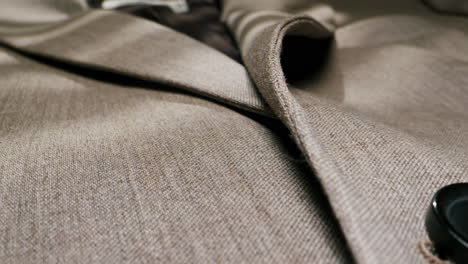 close-up of a beige suit jacket with button detail