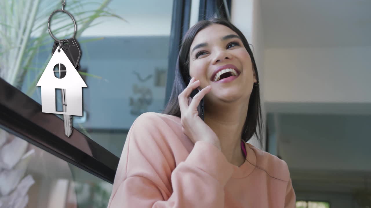 animación de llave de casa de plata y llave fob sobre feliz mujer biracial hablando por teléfono