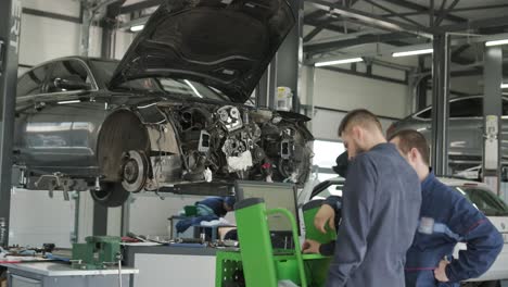 mechanic repairing car engine in auto workshop