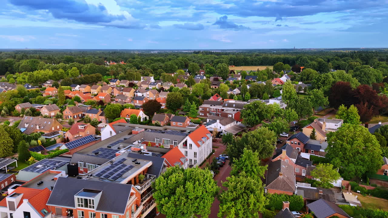Aerial drone view of Dutch town with red-roofed houses. Top view of a Dutch town with red-roofed houses, green trees, and residential streets
