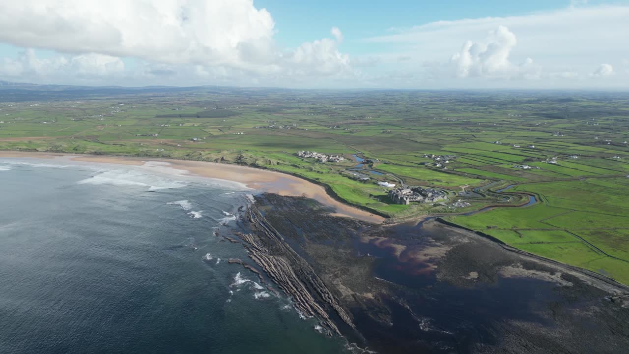 푸른 과 모래 해변이 있는 해안선, 구름이 가득한 파란 하늘 아래, 더그모어 만