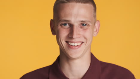 blond young man smiling and posing