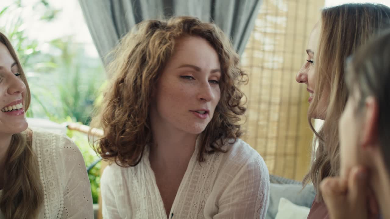 grupo de mujeres adultas sonrientes en la ducha de bebé tocando la campana de una mujer embarazada.