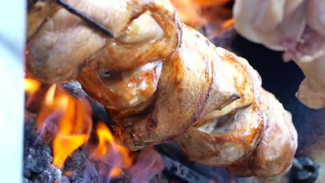 rotisserie chicken roasting over open flames