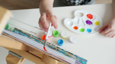 child painting on easel