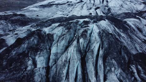 drone shot camera tilting downwards over solheimajokull glacier, iceland in 4k