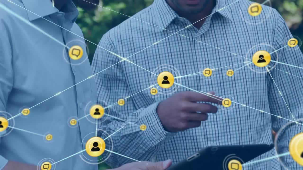animación de una red de iconos digitales sobre la sección media de dos hombres discutiendo sobre una tableta en un parque