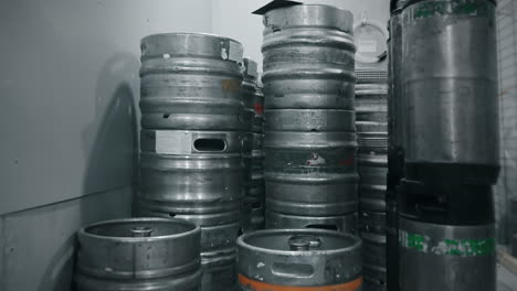 stacked beer barrels in a brewery storage room