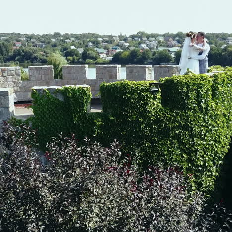 beautiful romantic wedding couple of newlyweds hugging in an old castle. aerial view square video