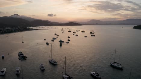 vista aérea distanciamiento de yates, barcos y veleros anclados cerca de la costa en una hermosa puesta de sol