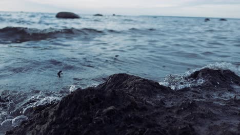 close up footage of ocean sea water waves hitting the shoreline during the summer time while is slightly cloudy