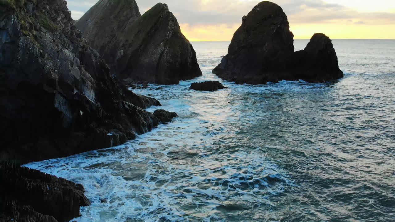 Formazione rocciosa nel mare al tramonto 4k