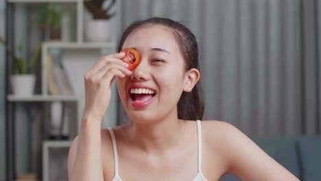 トマトスライスフェイスマスクを塗っている女性