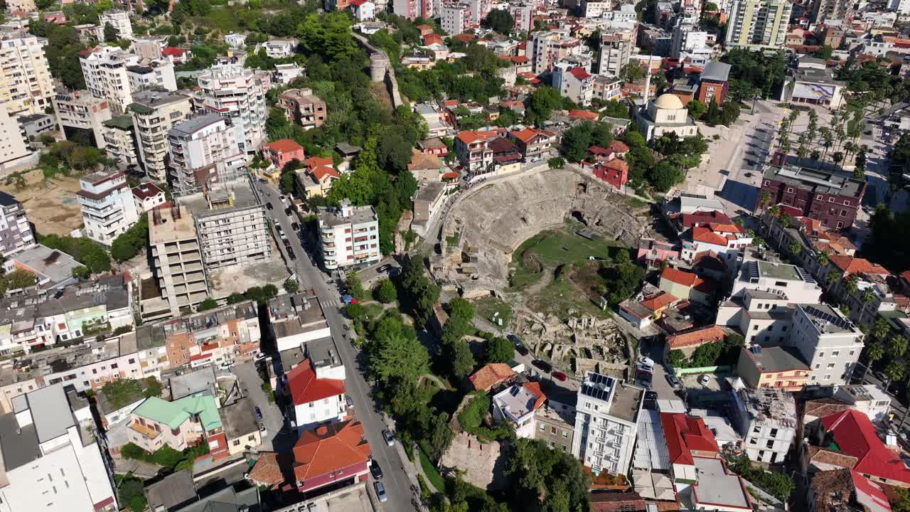 Aerial: amphitheatre of Durres in the city during the day in Albania, establishing drone shot