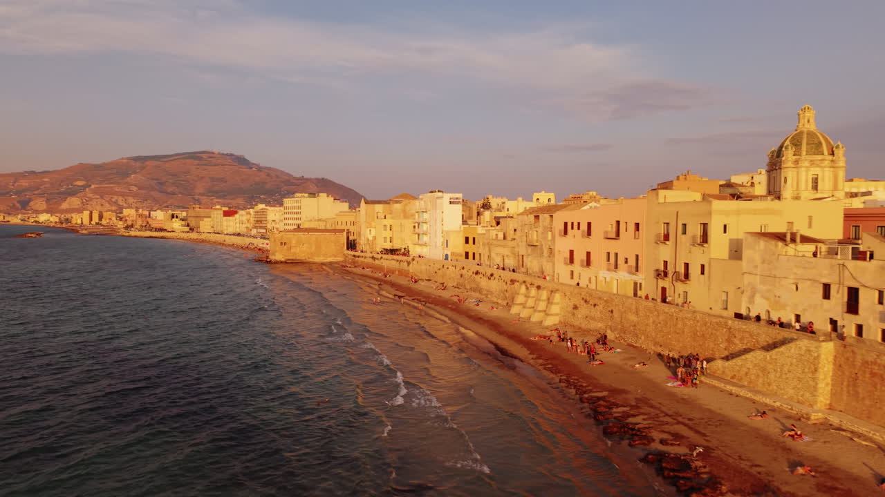 Solrig Trapani-kystlinje i tusmørke med varme toner og roligt vand