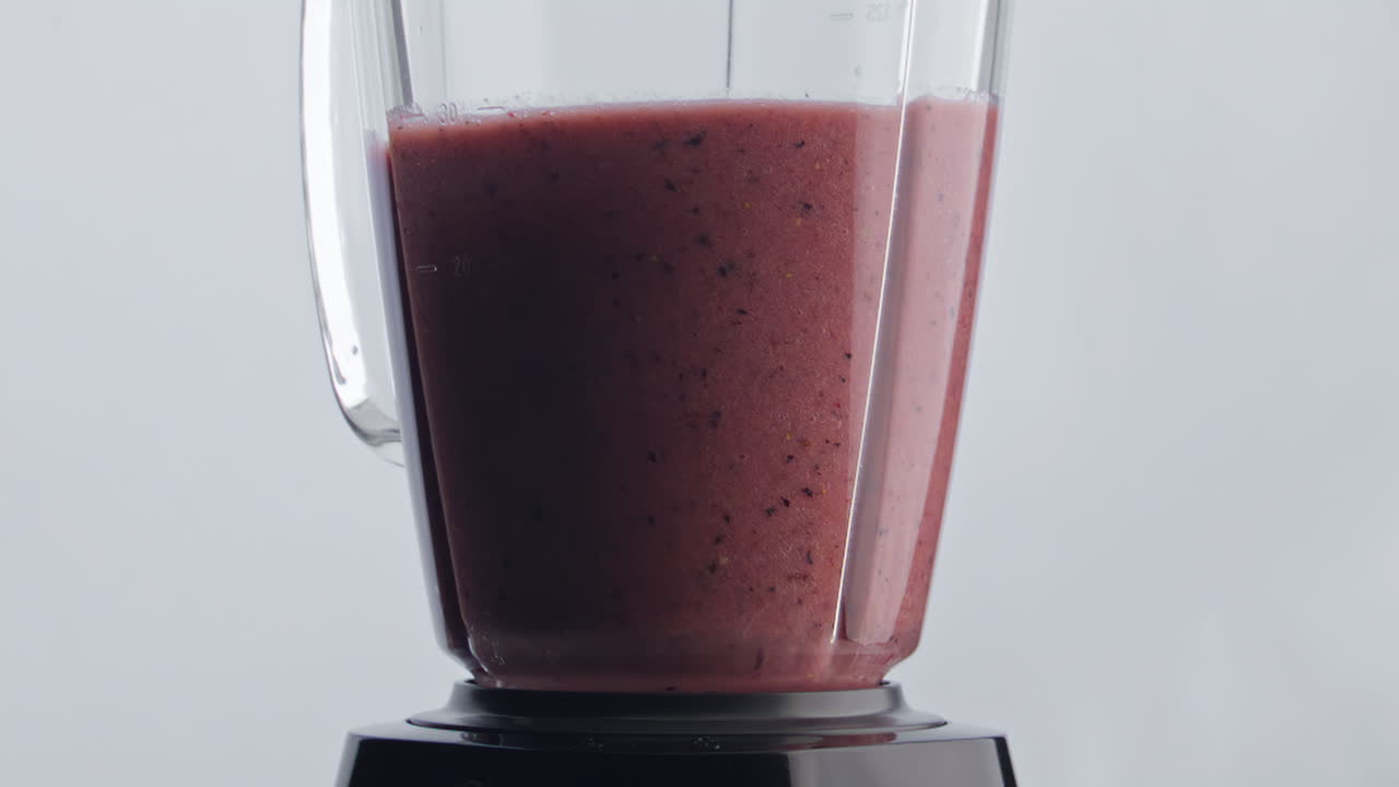 mezclador de mezclas de cócteles de vitaminas en cámara súper lenta de cerca. mezcla de bayas de frutas.