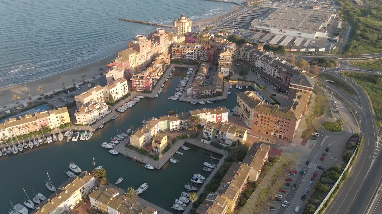 해가 뜨면 포트 사플라야의 공중 전망, 따뜻한 빛으로 마리나와 해안 도시를 보여줍니다.