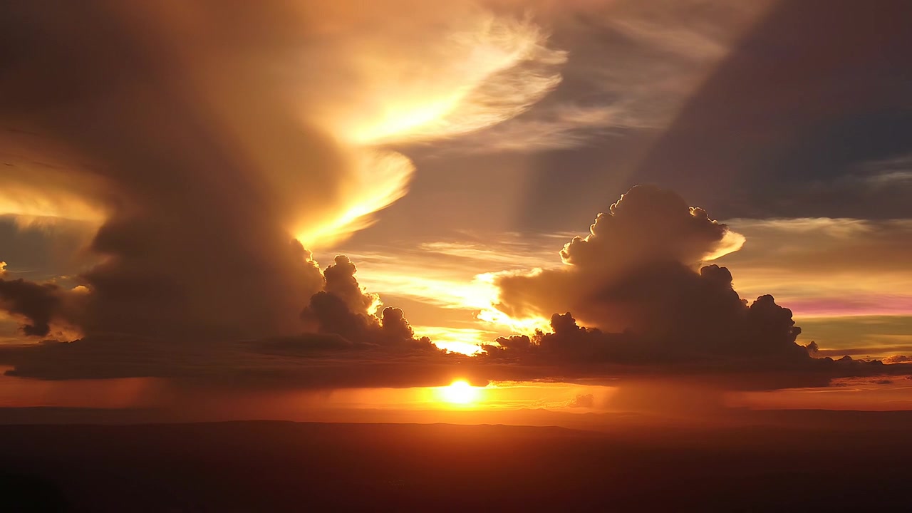 Majestätischer oranger Sonnenuntergang mit leuchtenden Wolken und Dämmerungsstrahlen