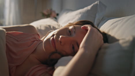 closeup morning girl rest in comfortable bed. smiling woman dreaming in sunlight