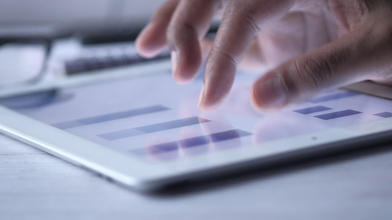 Person bruger en tablet til at se grafer og diagrammer.