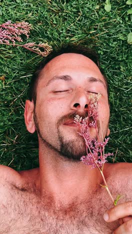 man relaxing in grass with flowers