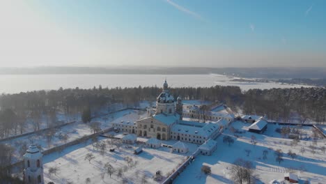 Aerial-view-of-the-Pazaislis-monastery-and-the-Church-of-the-Visitation-in-Kaunas,-Lithuania-in-winter,-snowy-landscape,-Italian-Baroque-architecture,-flying-away-from-the-monastery,-back-of-monastery