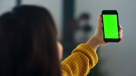 girl making video call on smartphone with green screen. pretty woman waving hand