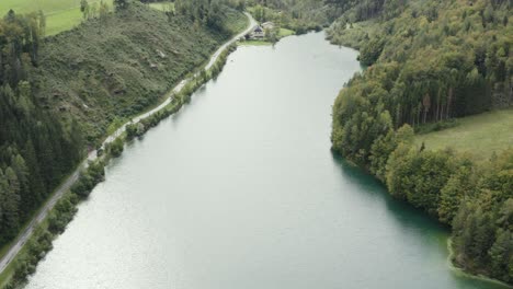 Vista-Al-Agua-Y-A-La-Montaña-Del-Embalse-De-Freibach-En-Austria-Hacia-La-Costa-Sur,-Tiro-De-Revelación-De-Inclinación-Aérea-Hacia-Arriba